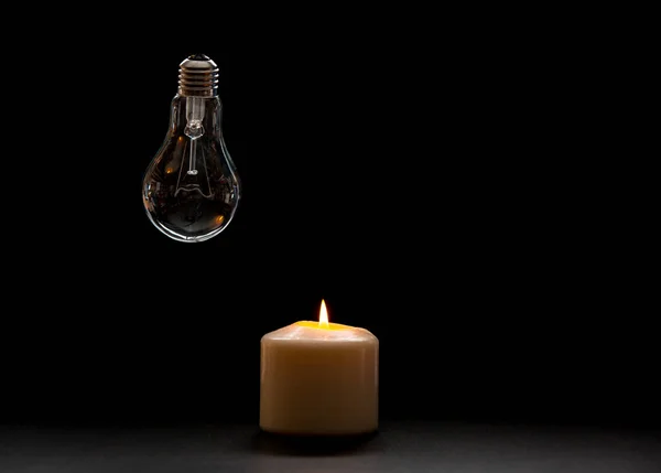 stock-photo-burning-candle-switched-light-bulb-dark-home-blackout-electricity-load